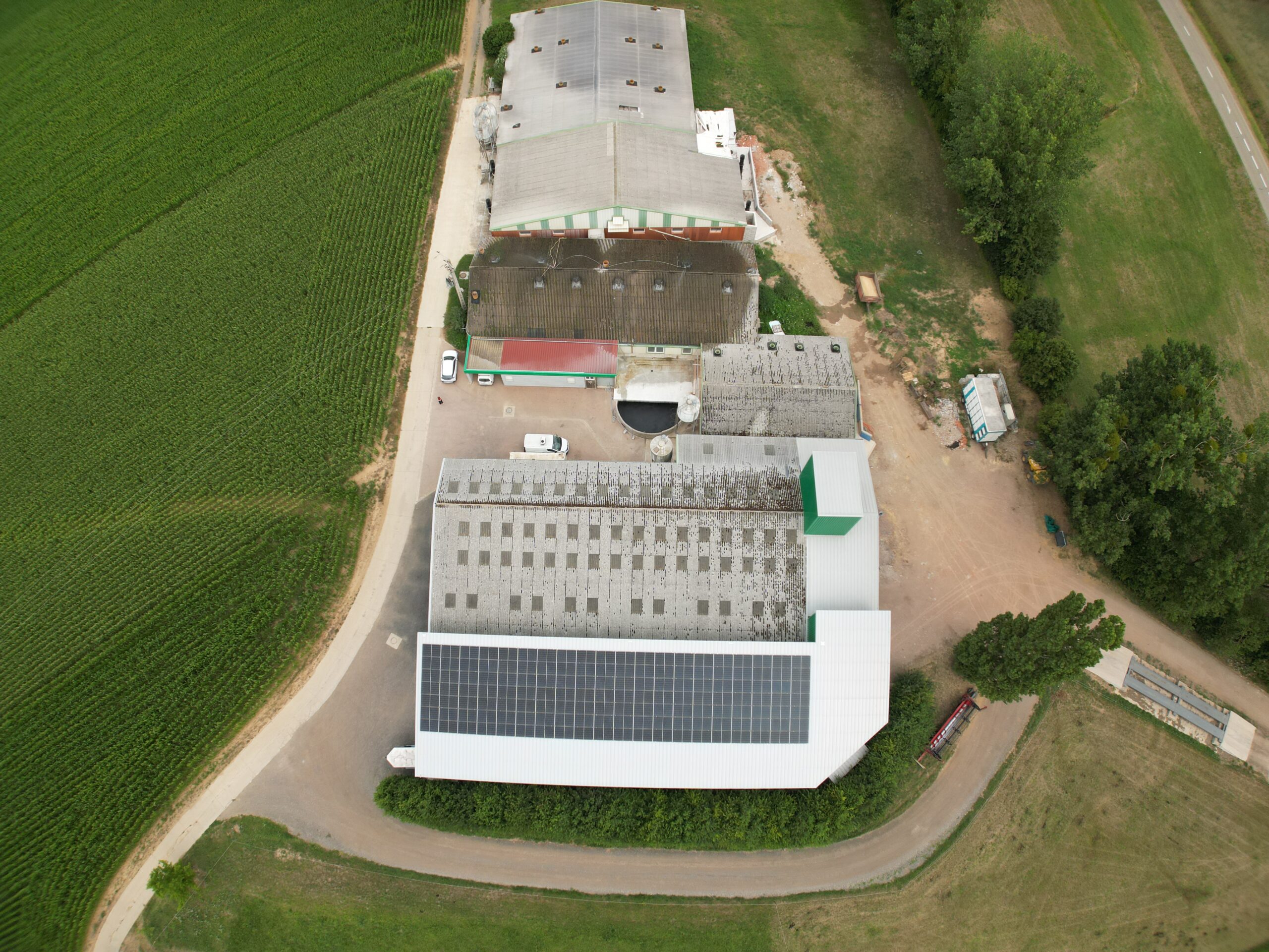 Installation de panneau solaire agriculteur : exploitation agricole vue du ciel avec bâtiments, silos et toiture solaire Calisun