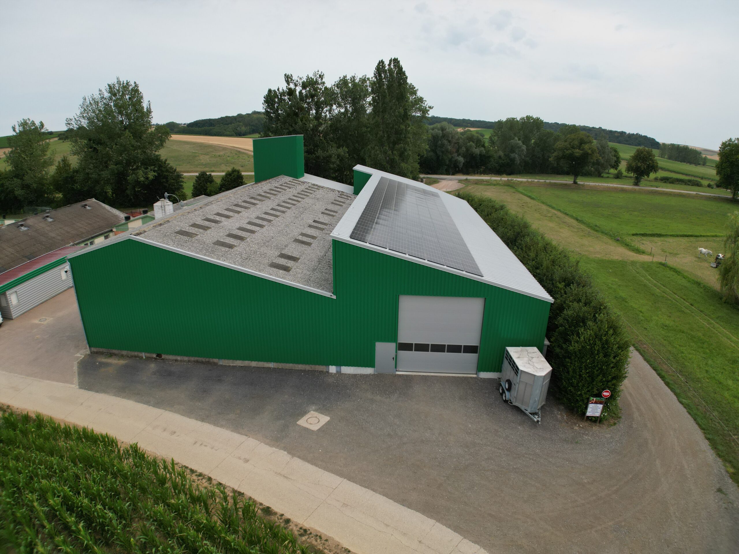 Panneau solaire agriculteur : vue aérienne d'un hangar agricole avec toiture équipée de panneaux photovoltaïques, installation Calisun